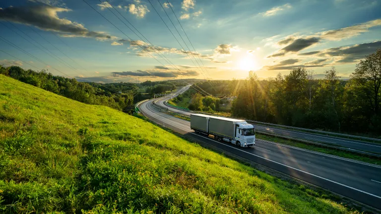 Kamion az autópályán közelít a naplementében